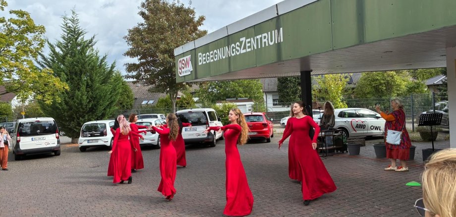 Frauen in roten Kleidern tanzen unter freiem Himmel