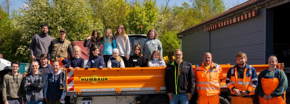 Menschen vor einem Traktor mit Anhänger