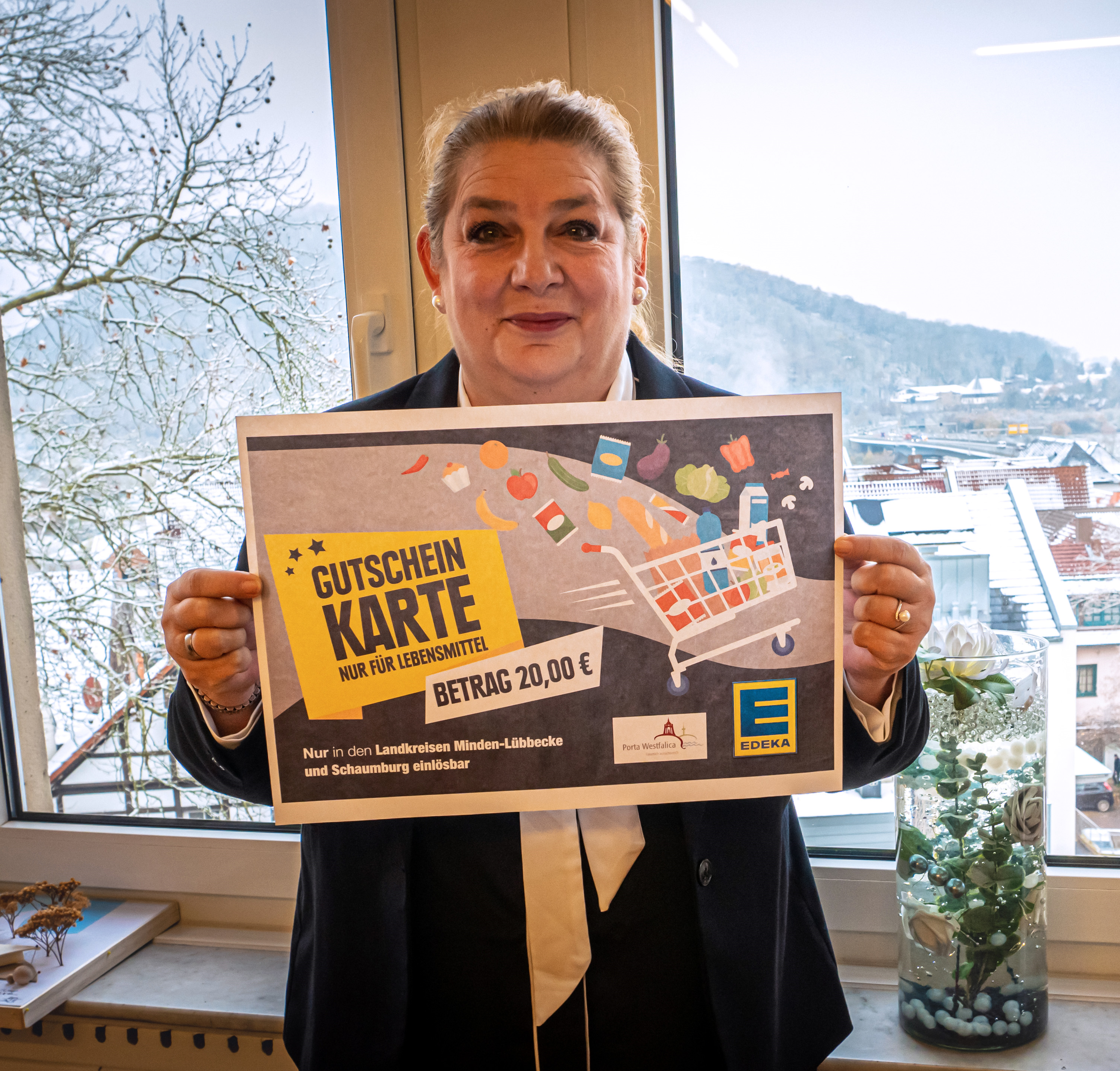 Bürgermeisterin Anke Grotjohann präsentiert die Gutscheinkarte für Lebensmittel