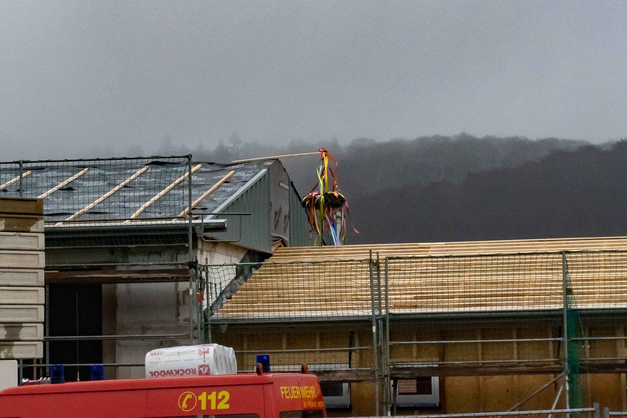 Ein Richtkrank an einem Balken auf einem Rohbau 