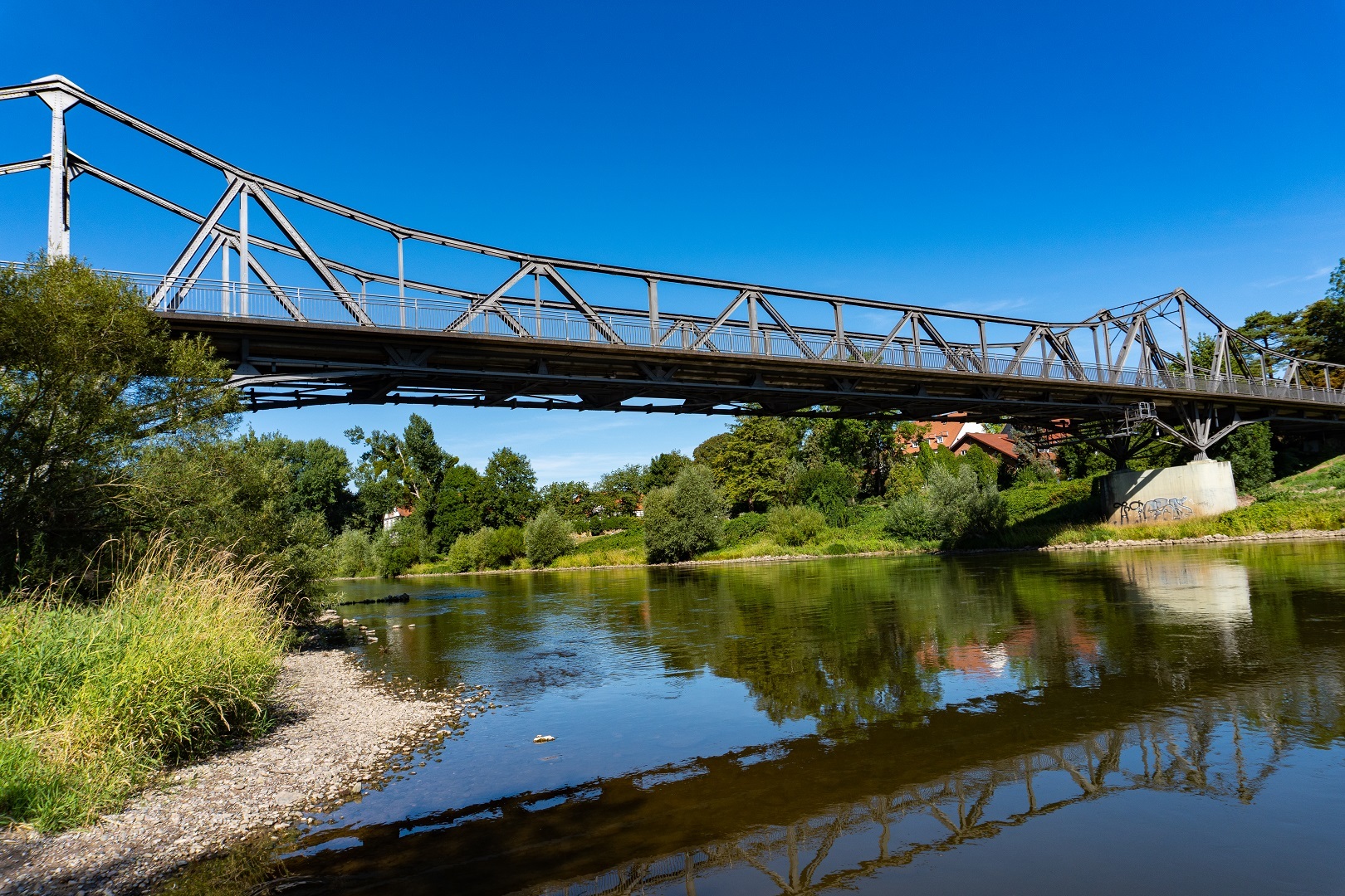 Eine alte Eisenbrücke führt über einen Fluss