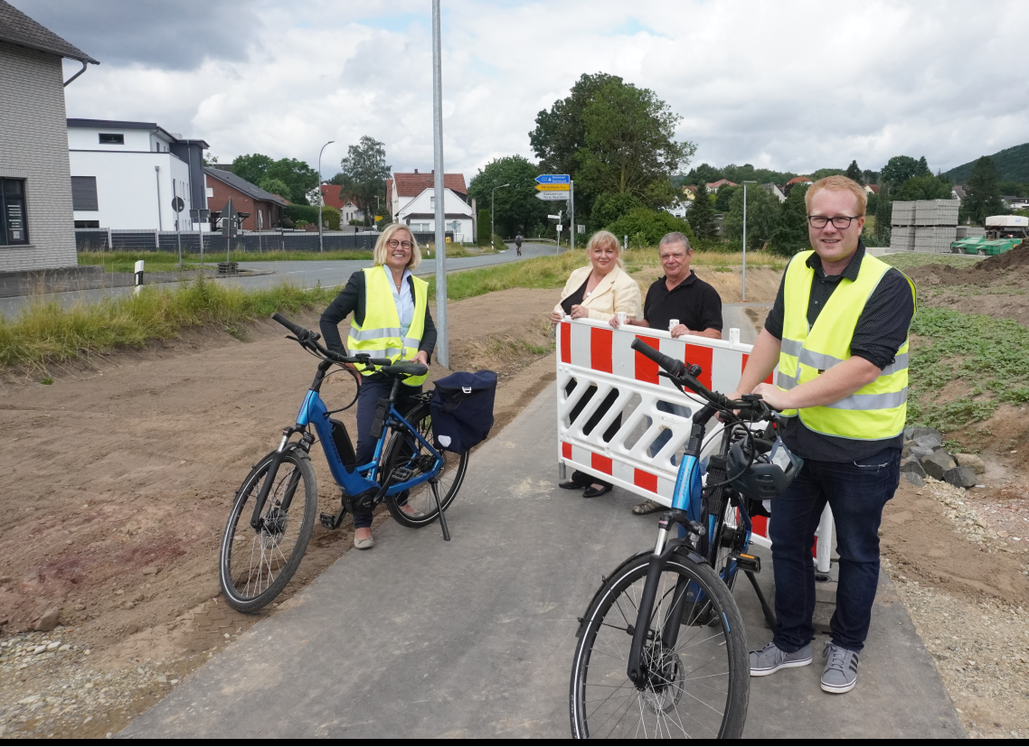 Die Absperrung für den Teilabschnitt des neuen Radweges am Kirchsiek wurde abgeräumt. V.l.: Fachbereichsleiterin Ute Schröder, Bürgermeisterin Anke Grotjohann, Ratsmitglied Hano Engels, Leiter des Sachgebietes Straßen Fabian von Behren